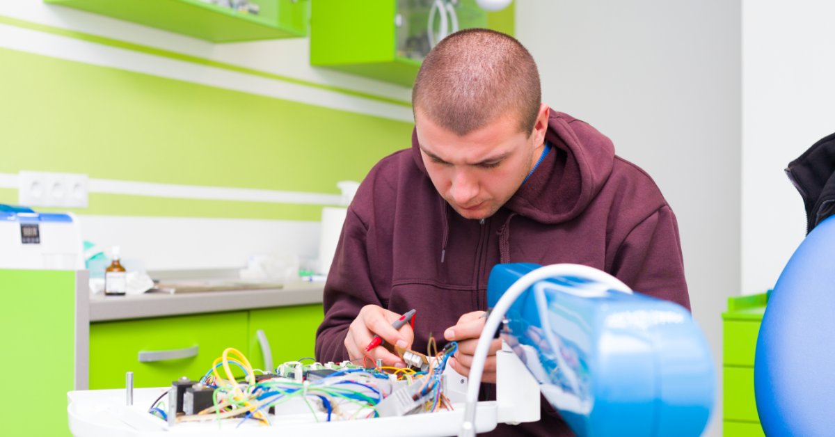 Medical Equipment Issues That Require Fast Action 2 A technician examines internal wiring and components while servicing an opened piece of clinical equipment.